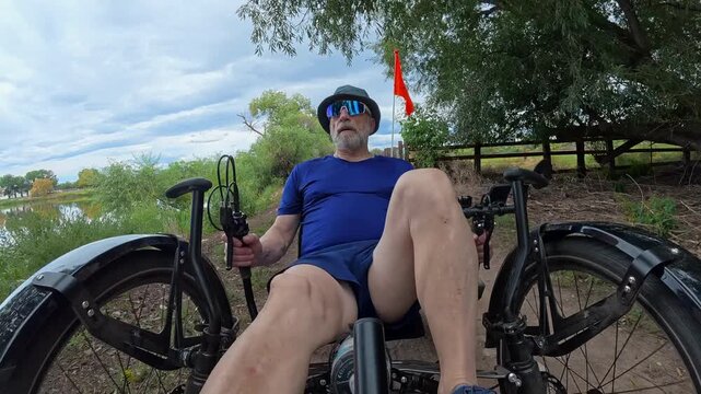 Senior cyclist is riding a full suspension recumbent tricycle on a rough gravel trail in northern Colorado - late summer scenery in Prospect Ponds Natural Area
