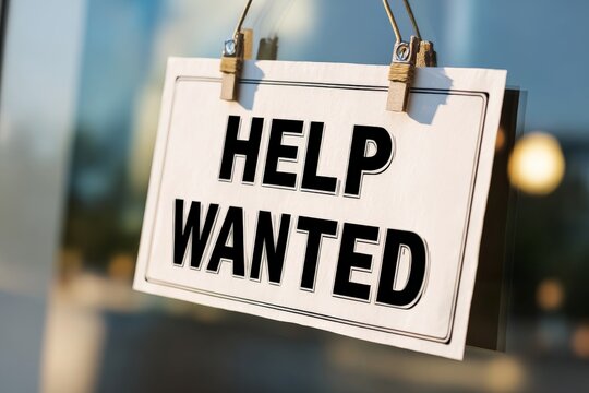 Classic 'HELP WANTED' sign being removed from a storefront, symbolizing the end of hiring, on a clean white background.