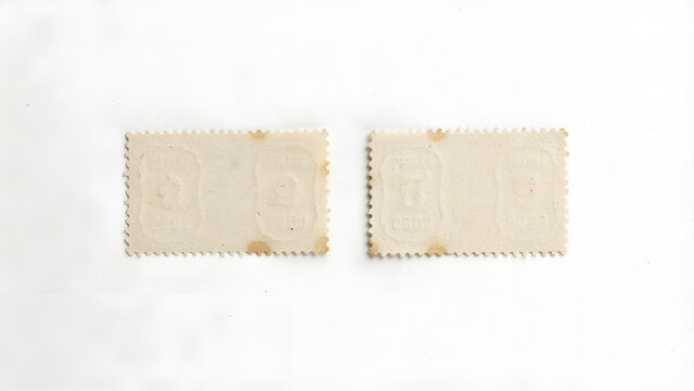 Back side of two vintage postage stamps with embossed details isolated on white background