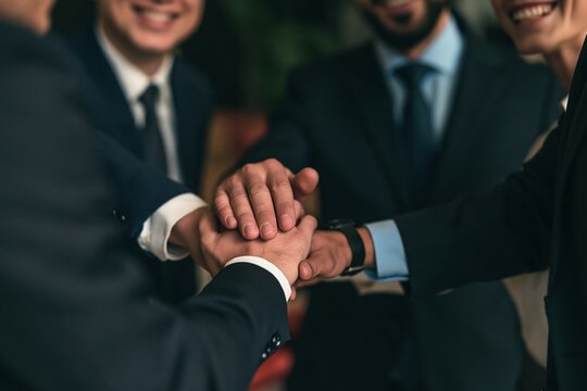 Diverse business team stacking their hands together in a sign of unity and corporate collaboration