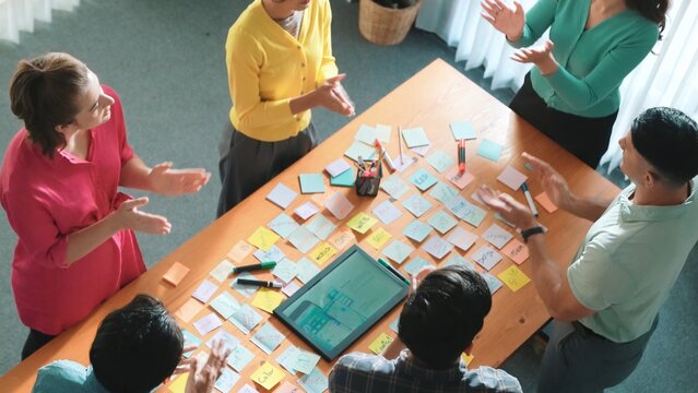 Aerial view of developer team discussing and showing digital program and writing by using Ux Ui design. Top down view of business people develop wireframe prototype for phone and computer. Symposium.
