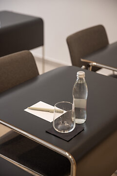 Close up of water bottle glass notepad and pen on conference desk