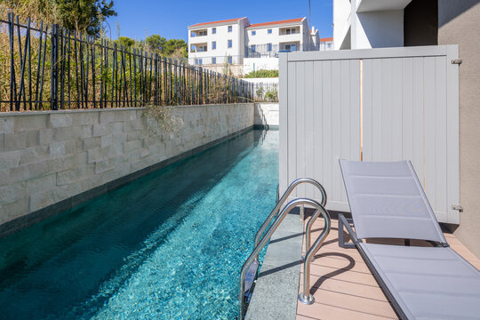 Private luxury swimming pool with sun lounger at modern resort villa