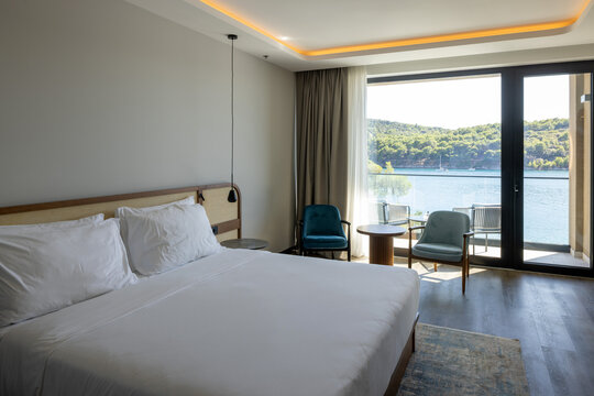 Luxury hotel bedroom suite with king bed and sea view balcony