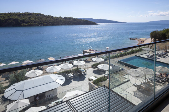 High angle balcony view of resort beach and swimming pool