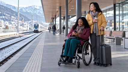 Obraz premium Woman Using Wheelchair Traveling by Train with Companion in Winter