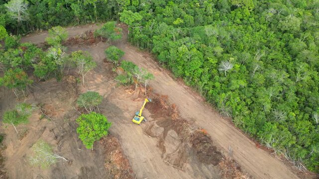 Aerial drone flyover documenting native rainforest being deforested with the use of an excavator in the Brazilian Amazon