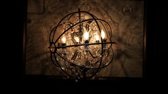 Elegant vintage chandelier with crystal accents illuminates antique map background