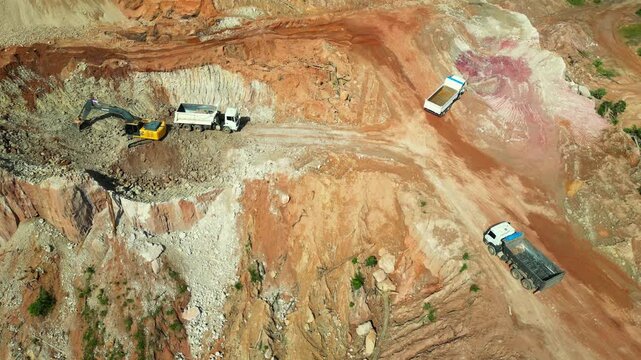 Aerial drone flyover of an open-pit aggregate mining site in the Brazilian Amazon. The footage captures the mining operation, excavation areas, heavy machinery, exposed earth, and the surrounding rain
