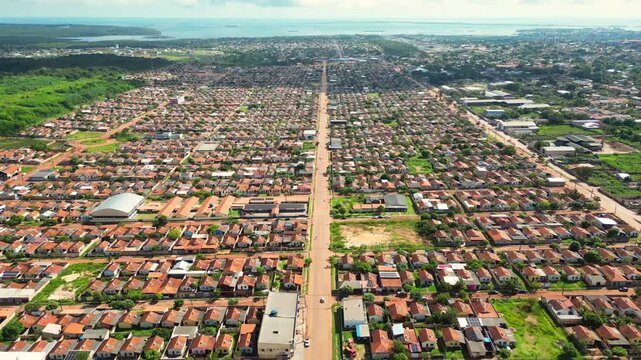 Aerial drone flyover of a large government-built social housing development in Santar&eacute;m, Par&aacute;, Brazil. The footage captures the extensive residential neighborhood, organized street layout, surrounding