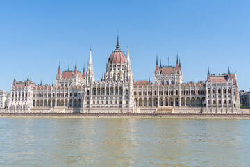 Obraz premium The neo-Gothic building of the Hungarian Parliament on the banks of the Danube in Budapest