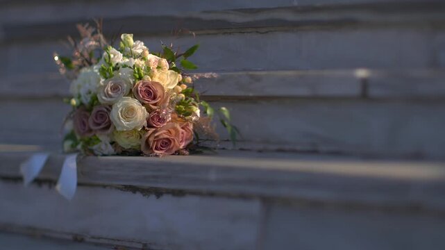 Elegant wedding bouquet with roses and hydrangeas resting on stone steps