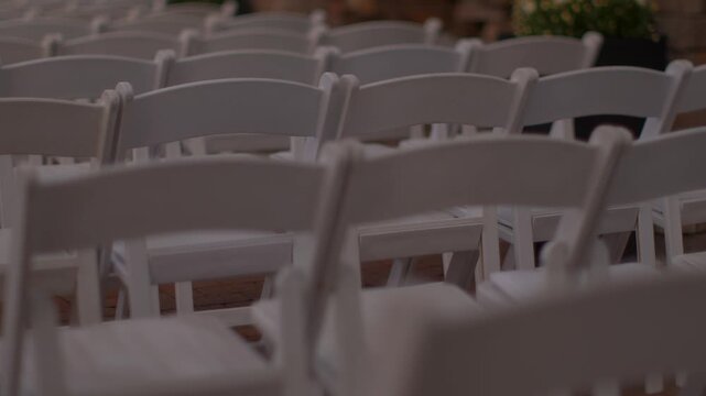 Rows of empty white chairs set up for an event or ceremony