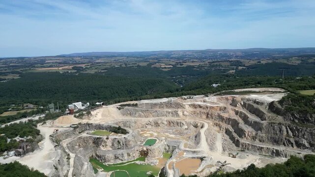 Hingston Down, Cornwall, England: DRONE VIEWS: The drone circles around and behind the granite quarry showing both the stepped quarrying technique and the pools of water mineralised with Arthurite.
