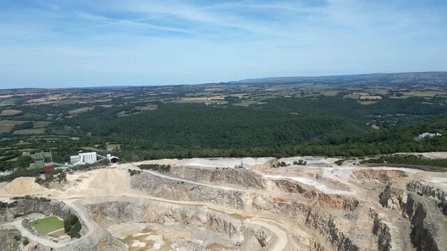 Hingston Down, Cornwall, England: DRONE VIEWS: The drone circles around and behind the granite quarry showing both the stepped quarrying technique and the pools of water mineralised with Arthurite.