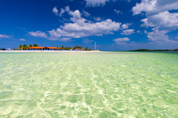 Tropical sandy beach and an exotic view of the Atlantic Ocean against a blue sky with clouds in Cuba, Caribbean – background for projects, wallpaper © anettastar