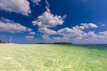 Tropical sandy beach and an exotic view of the Atlantic Ocean against a blue sky with clouds in Cuba, Caribbean – background for projects, wallpaper © anettastar