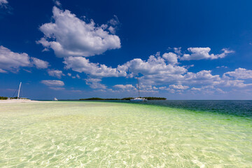 Tropical sandy beach and an exotic view of the Atlantic Ocean against a blue sky with clouds in Cuba, Caribbean – background for projects, wallpaper © anettastar