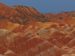 Colorful Zhangye Danxia mountains in Gansu, China, featuring layered rainbow rock formations, dramatic desert scenery and striking geology in a famous Danxia geopark. © JEREMIE