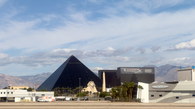 LAS VEGAS, NV, APR 28, 2026: Luxor's black glass pyramid and Sphinx replica in Las Vegas, with the HyperX Esports Arena sign and desert mountains behind under a partly cloudy sky