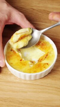 Large portion of crema catalana is lifted on spoon, close up. Food blogger shows creamy custard under crisp caramel top. Tasting shot suits recipe post, social media video or restaurant review.