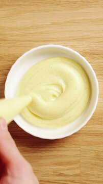 Pastry chef pipes custard from bag into ramekin. Catering workflow keeps dessert portions equal for efficient service. Individual cups suit banquet, buffet, wedding reception or corporate event.