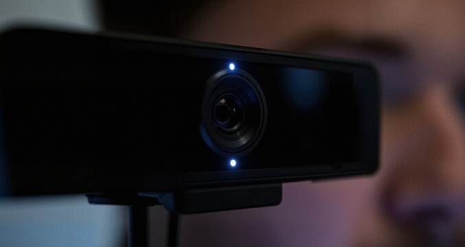 The webcam light is a tiny, unblinking eye, watching his every move.
