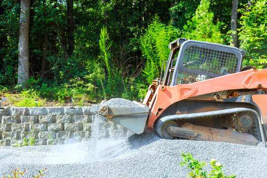 Construction equipment moves gravel in forested area