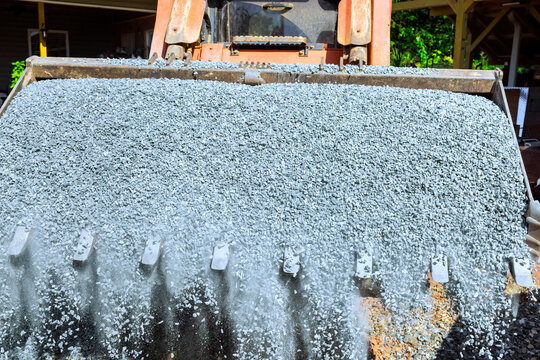 Heavy machinery spreads gravel at construction site