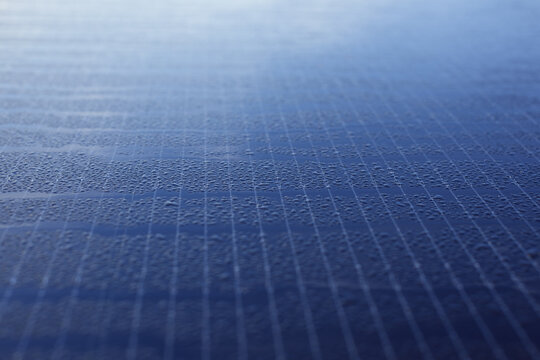 Close-up of photovoltaic modules covered with drops of morning dew