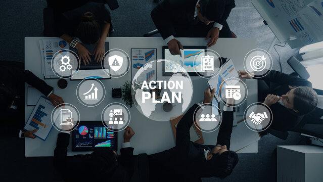 A diverse business team engages in strategic planning using charts and graphs in a sleek office setting, focusing on creating an effective action plan for future success. Ledger