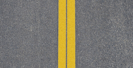 Top down view of asphalt road surface with double yellow center lines for traffic lane separation © Nurjahan _Studio