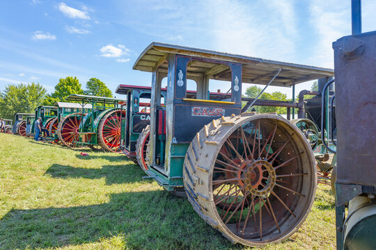 A line up of antique steel wheeled tractors. 
