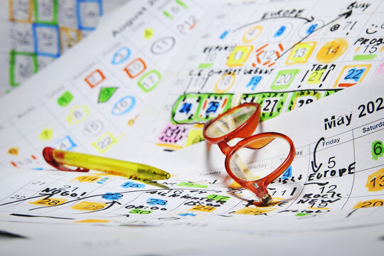 Heap of calendar sheets with appointments and notes, spectacles and a pen. Business concept,beat the clock,overwoked,bureaucracy