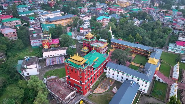 Low-altitude drone reveal showcasing the striking red and gold architecture of the Sherabling monastery in the Himalayan town Bir Himachal Pradesh
