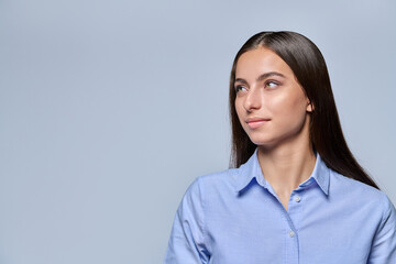 Obraz premium Young female student looking aside with thoughtful expression on light background