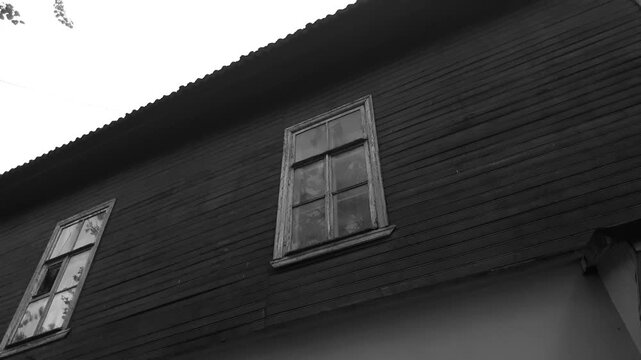 An old wooden house. A dilapidated wooden house with windows.