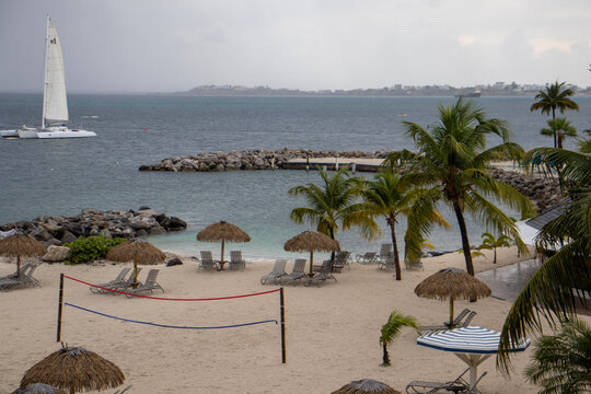 Resort beach with palapas and volleyball net on an overcast day
