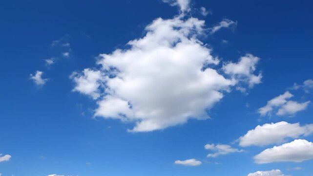 Soft white cumulus clouds drifting gently across clear blue sky