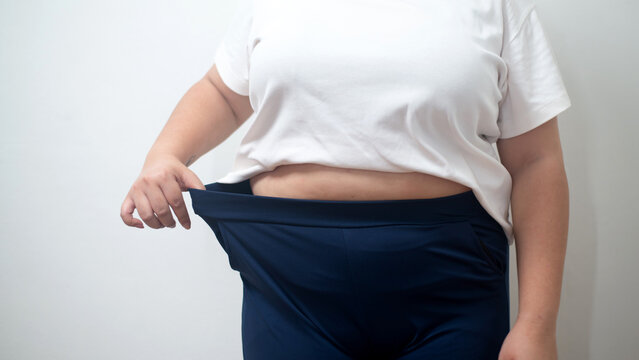 Plus-Size Woman Measuring Her Body with a Measuring Tape While Wearing Weight-Loss Shapewear