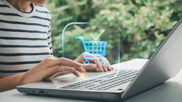 A young woman using a laptop computer receiving order confirmation message with a notification, representing successful online shopping transaction, payment approval and e-commerce checkout completion