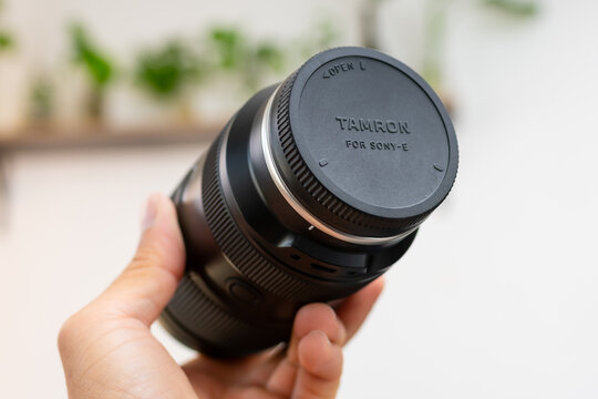 ZAPOPAN, MEXICO - SEPTEMBER 11, 2026: Hand holding a rear capped Tamron lens.