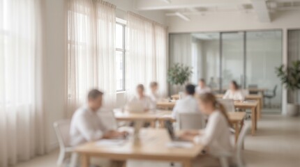 Fototapeta premium Blurred figures collaborate in a modern light filled open office setting