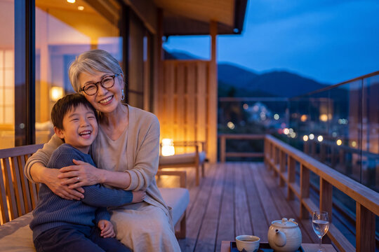 敬老の日におばあちゃんと孫が落ち着いた高級旅館で笑顔を交わしながら心温まるひとときを過ごしている。