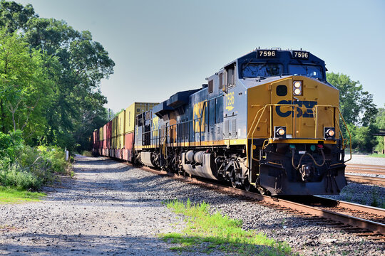 A pair of CSX Transportation locomotives lead an intermodal freight train through a busy rail juntion in south suburban Chicago. 