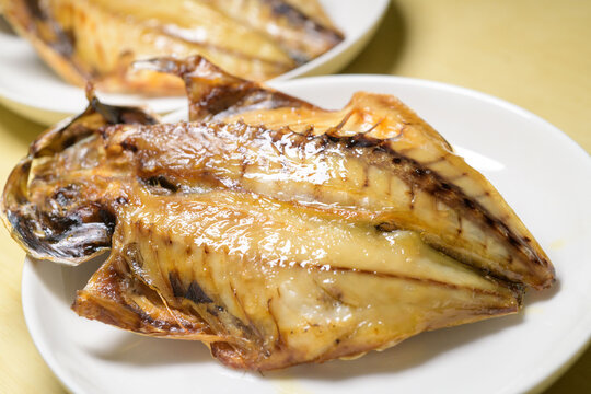 Grilled horse mackerel with beautiful golden-brown char on white plate, Japanese salt-grilled fish