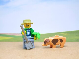 Fototapeta premium Indonesia - November 23, 2023 : Mini toy figure of lego at table with blurred background. Farmer concept design.