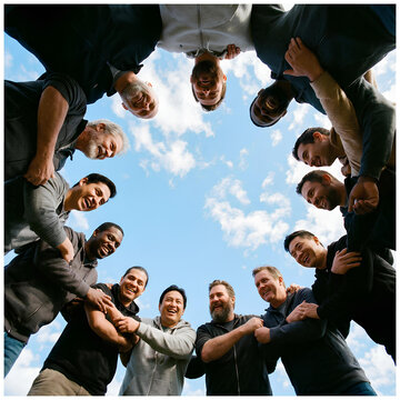 Diverse mens circle teamwork unity friendship outdoors looking up at sky
