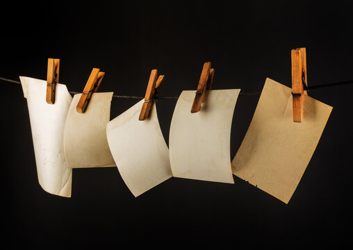 Isolated photo of blank vintage photos hanging on black background.