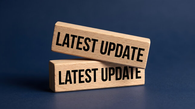 Two wooden blocks stacked on a dark blue background with the text latest update printed on them business information